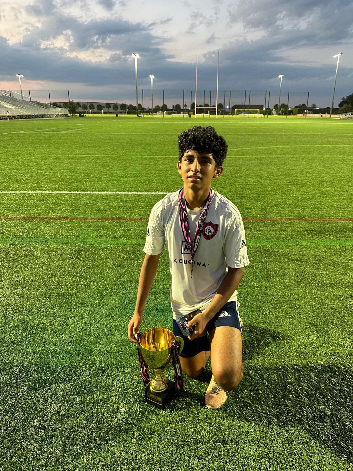 Stefano with a soccer cup on the field